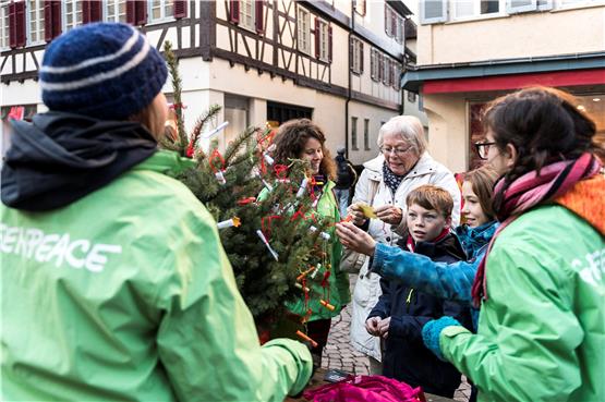 Rebecca Bösch (hinter dem Weihnachtsbäumchen) zieht mit einer Passantin einen Zettel. Bild: Carolin Albers
