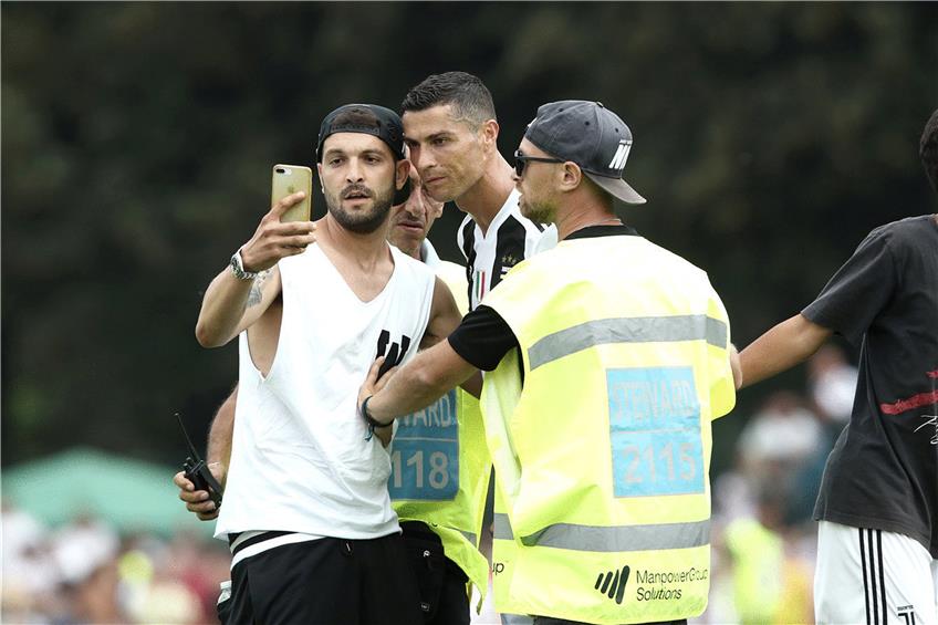 Selfie mit dem Superstar: Cristiano Ronaldo bei einem Testspiel mit einem aufdringlichen Juve-Fan. Foto: Isabella Bonotto/afp