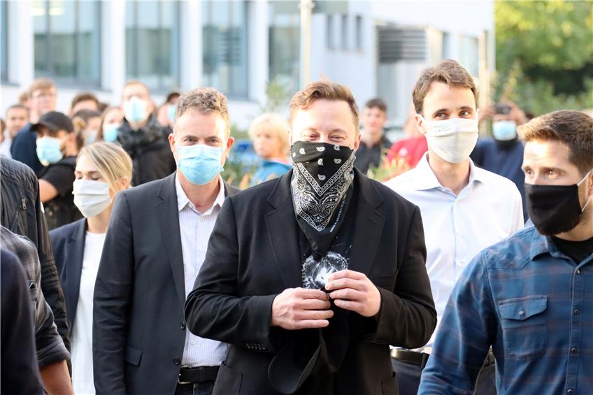 Tesla-Chef Elon Musk (Mitte) mit Maske und Curevac-Gruender Ingmar Hoerr (links dahinter) zu Fuß unterwegs im Tübinger Technologiepark beim Besuch des Tesla-Chefs beim der Biopharma-Unternehmen Curevac Anfang September. Bild: Ulmer
