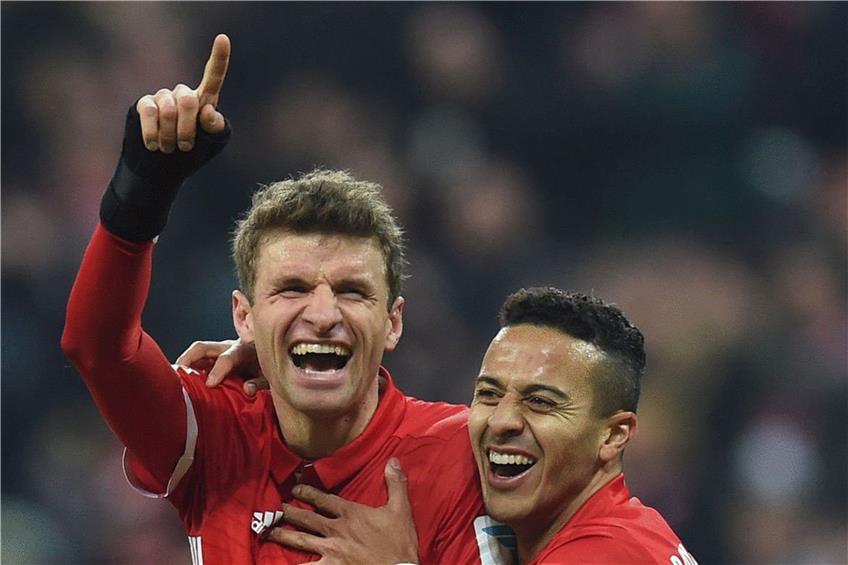Thomas Müller (links) erzielte im Heimspiel gegen Wolfsburg sein erstes Saisontor in der Bundesliga, Thiago gratulierte. Foto: afp