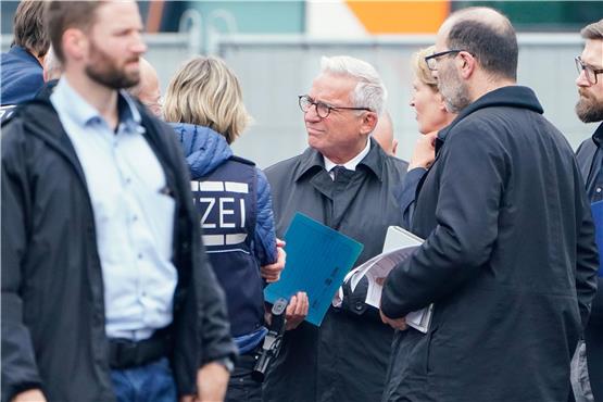 Thomas Strobl, baden-württembergischer Innenminister spricht am Tatort mit Polizeibeamten. Foto: Uwe Anspach/dpa