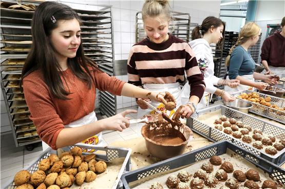 Tunken, streichen, kleckern: Beatrice Brazovan und Jael Reutter mitten im Schokoladenlebkuchenherstellungsprozess. Bild: Anne Faden