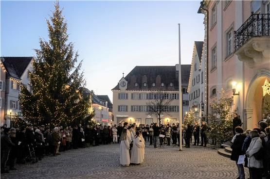 Um den Weihnachtsbaum auf dem Rottenburger Marktplatz versammelten sich die Teilnehmer des ökumenischen Gottesdienstes, unter anderem Ministranten und Musiker der Stadtkapelle, am Silvesterabend. Bild: Andreas Straub