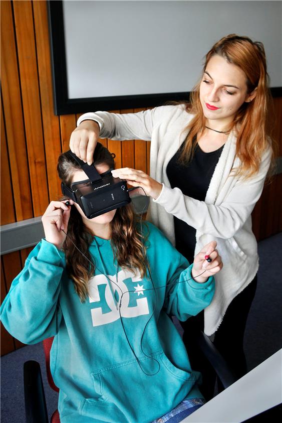 Vasilena Terziyska stellt die Virtual-Reality-Brille für das perfekte Rezeptionserleben ein. Über die Kopfhörer sprechen die Darsteller mit dem Probanden. Bild: Faden