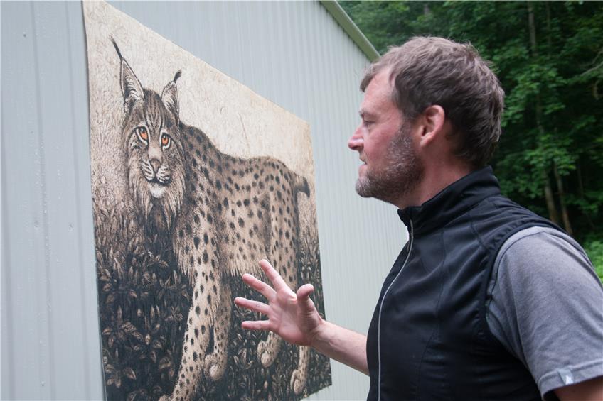 Vereinsmitglied Heiko Hinzmann präsentiert eine der vergrößertenRadierungen mit Tiermotiven von Kunstmaler Norbert Stockhus.