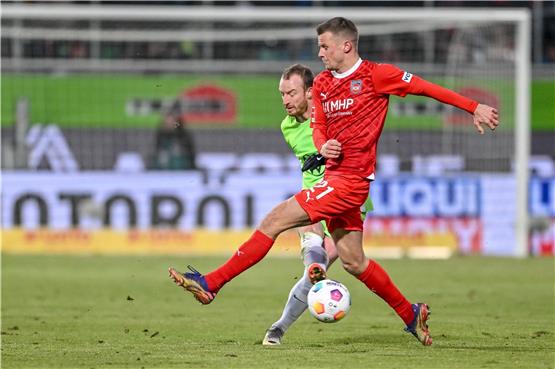 Wolfsburgs Maximilian Arnold (l) in Aktion gegen Heidenheims Adrian Beck (r). Der Mittelfeldspieler fällt verletzt aus. Foto: Harry Langer/dpa