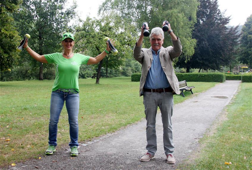 „YoungGo“-Instruktorin Silke Hassmann zeigt im Glatter Schlosspark die Hantel-Übung „Jumping Jack“, Ortsvorsteher Helmut Pfister kräftigt die Muskeln mit Hilfe der mit Patronen gefüllten Hanteln bei der Übung „Holzhacker“.